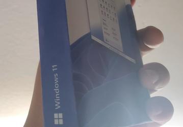 С новым меню Пуск в самом центре. На фото показали коробку Windows 11 Pro