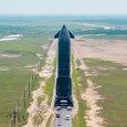 Starship даже без ускорителя выглядит абсолютным гигантом на фоне машин и столбов ЛЭП. Корабль везут на стартовую площадку